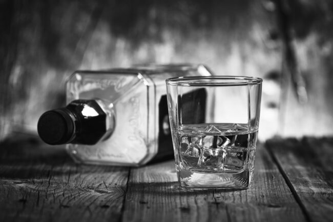 A,Glass,Of,Whiskey,And,Empty,Bottle,Of,Whiskey,On