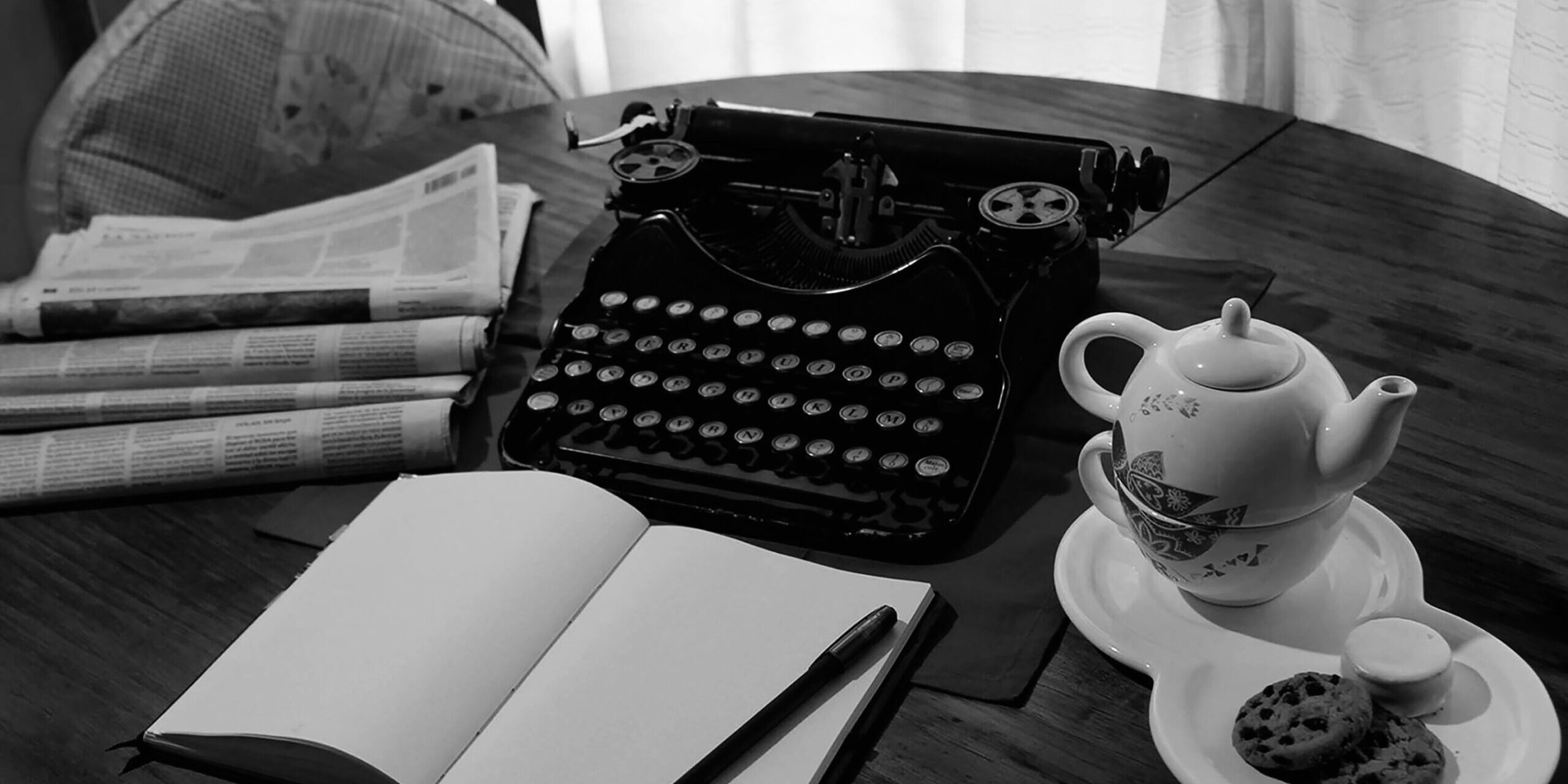 Vintage,Typewriter,On,Wooden,Table,Accompanied,By,A,Teapot,,A