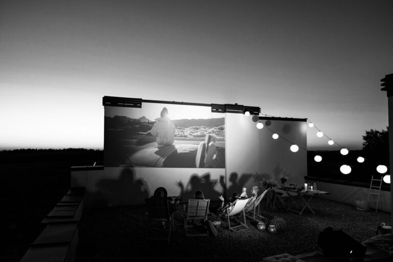 Small,Group,Of,People,Watching,Movie,On,The,Rooftop,Terrace