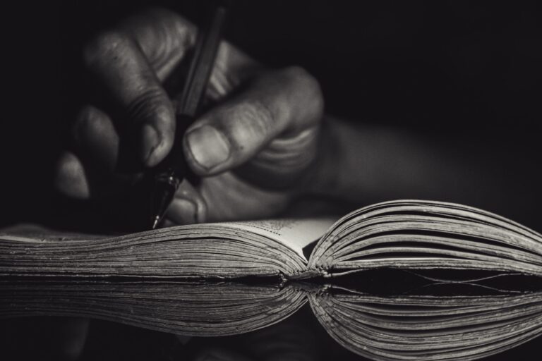 Close-up,Of,A,Man’s,Hand,Writing,On,Paper,At,Night,